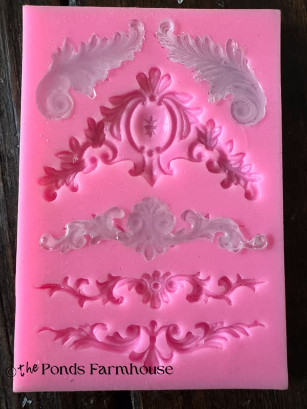 Silicone mold filled with hot glue to create decorative trim for drawer fronts