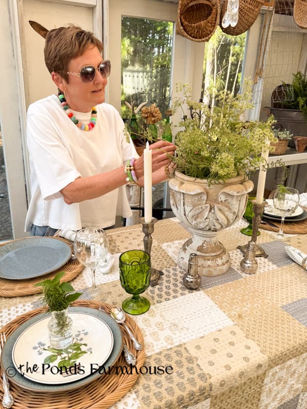 arranging queen ann's lace in urn for summer tablescape