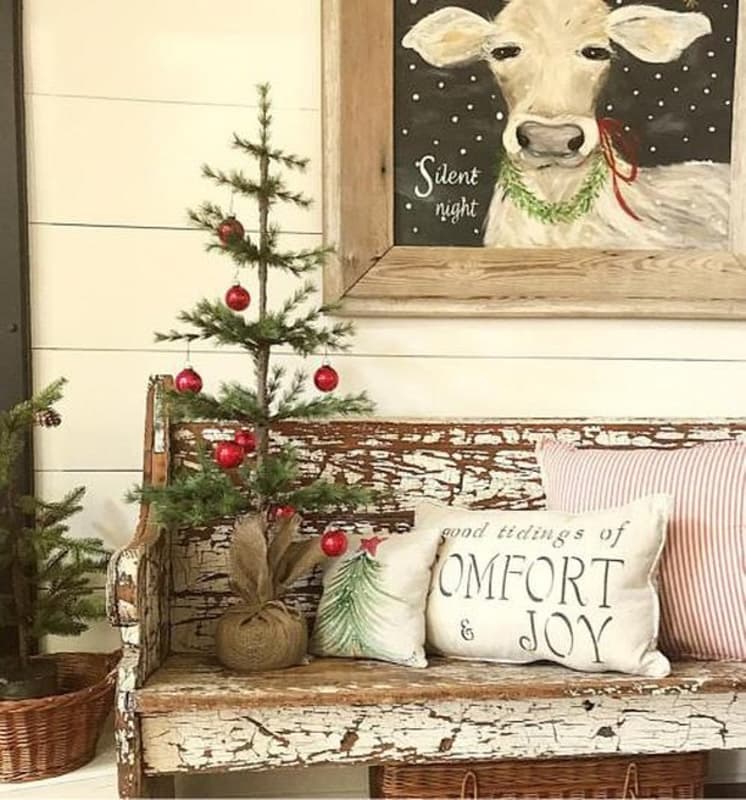 Mini Christmas Tree on chippy church pew with silent night cow painting.