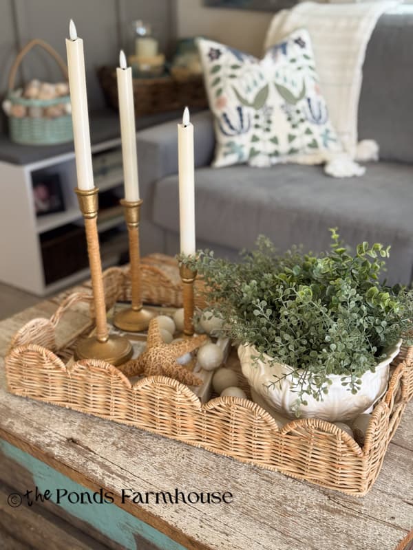 DIY rattan brass candlestick holders thrifted container with greenery & woven tray on coffee table