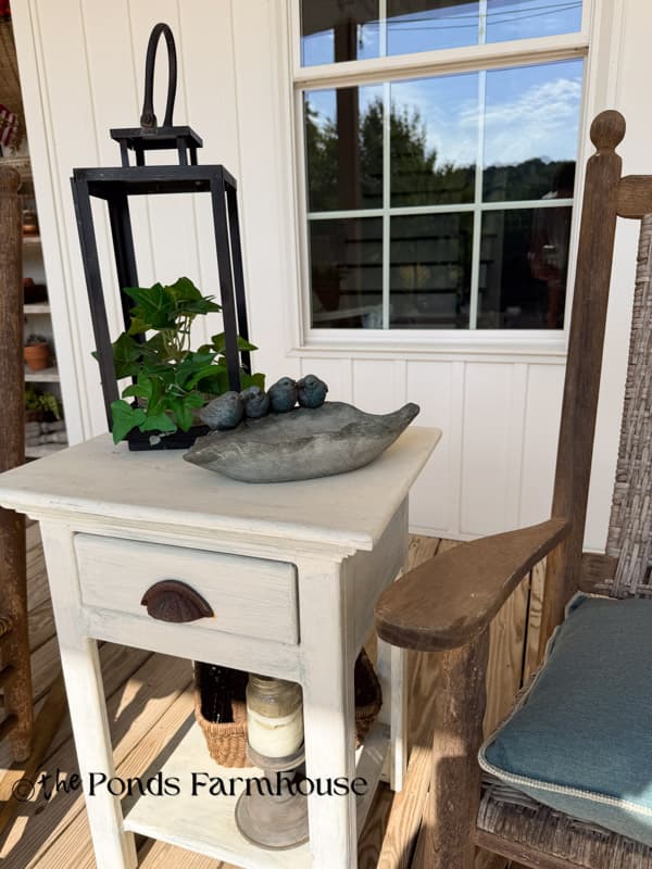 Faux ivy in repurposed lantern on porch side table