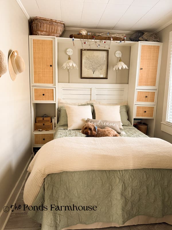 Rudy on bed with rattan cabinets and DIY wall scones