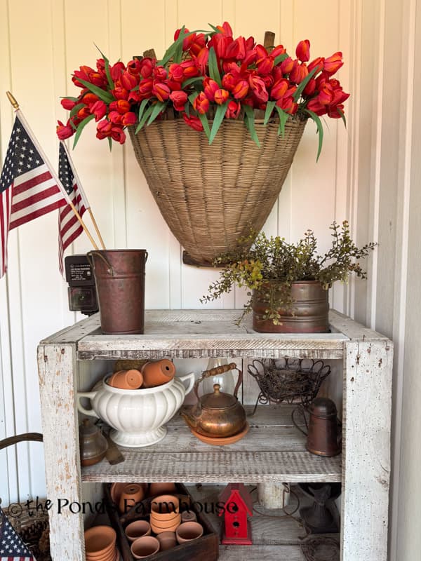 Vintage wall basket with faux tulips over primitive cabinet