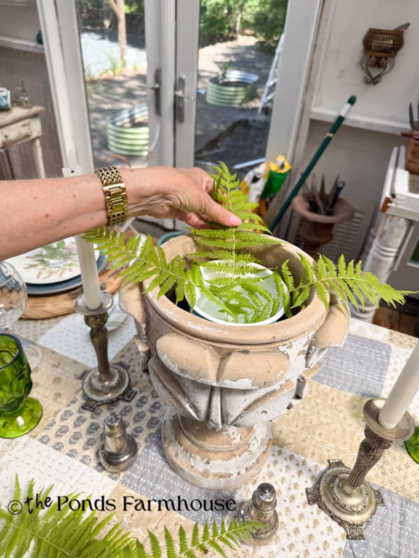 adding ferns to containers to create a wildflower centerpiece for summer garden party table