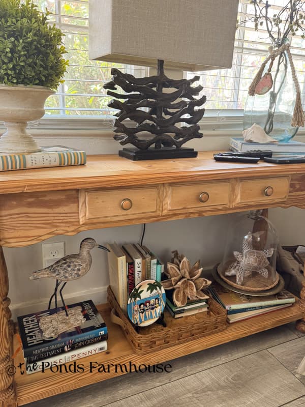 thrifted sofa table filled with coastal decor and books