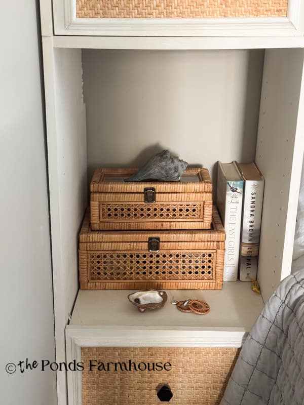 two rattan boxes and a oyster shell trinket dish in bedroom storage shelf