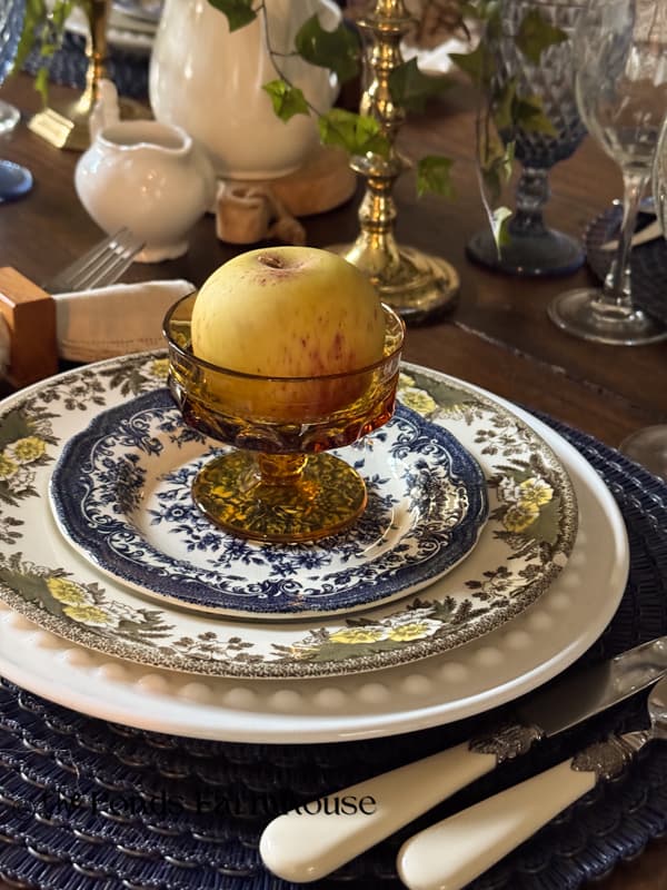 Close up of Early Fall place setting with blue and brown dishes and apple