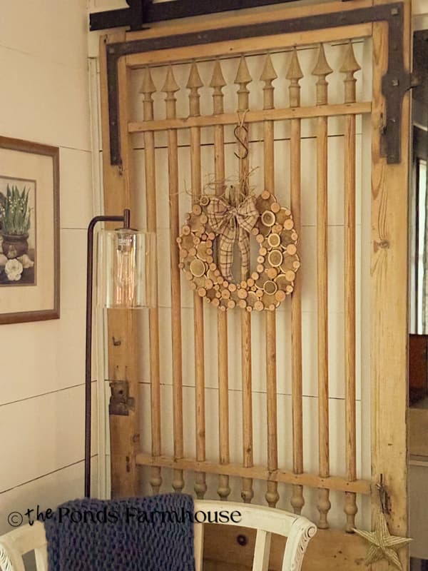 Easy DIY Wood Slice Pumpkin Wreath for Fall decor on barn door.