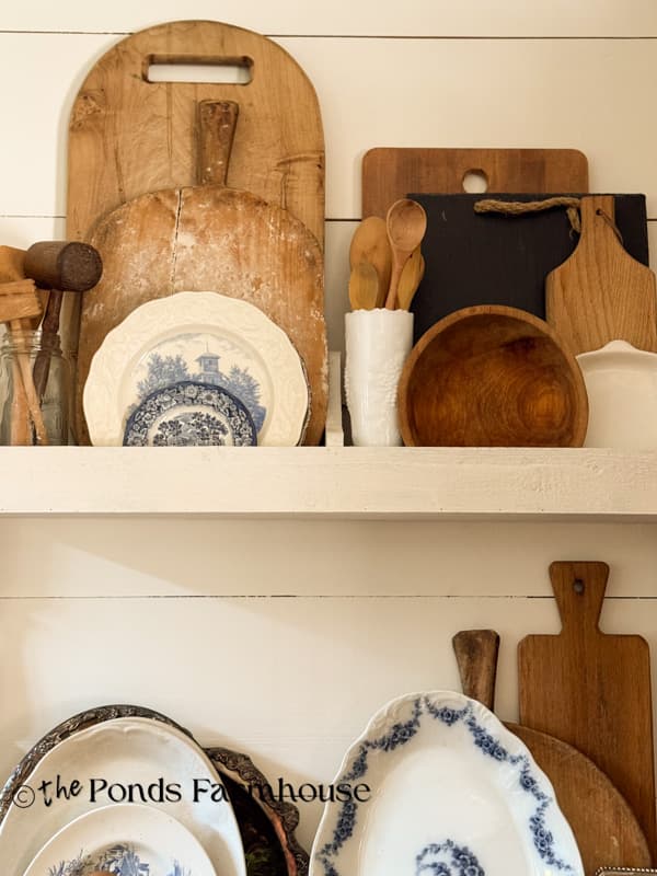 Stack of breadbroads, cutting boards and platters in plate rack