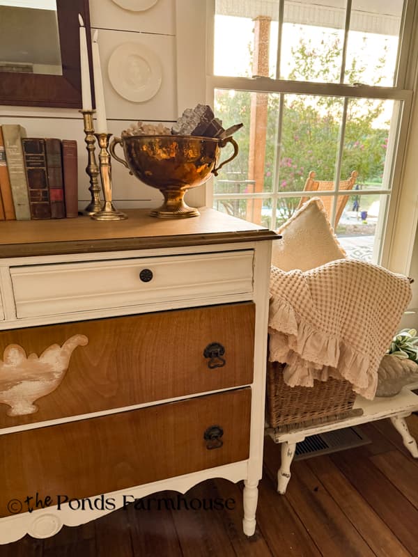 Vintage basket filled with cozy neutral linens beside entry table for late summer/early fall decorating