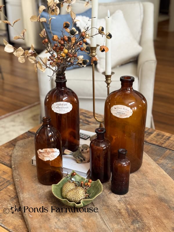 coffee table decorated with vintage amber bottles for early fall decorating