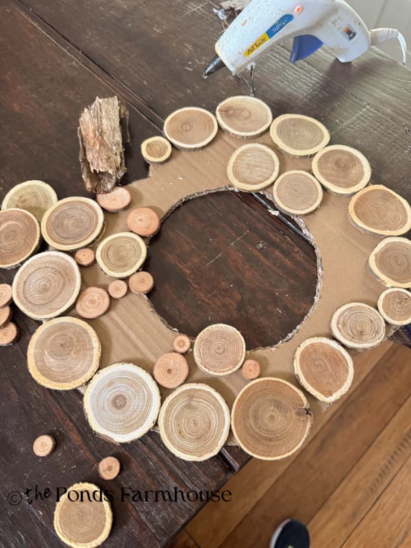 Lay out the wood slice design on the cardboard frame