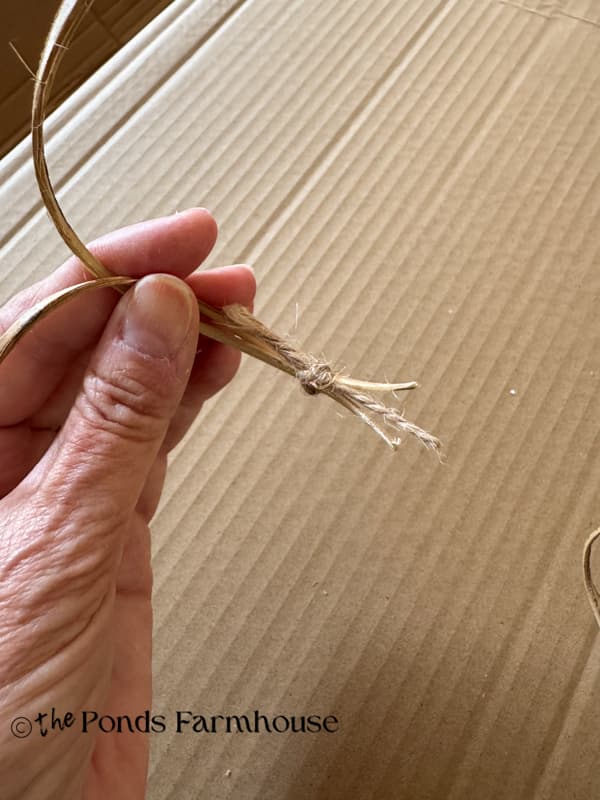 tie several natural curly twig branches with jute twine to use on pumpkin wreath