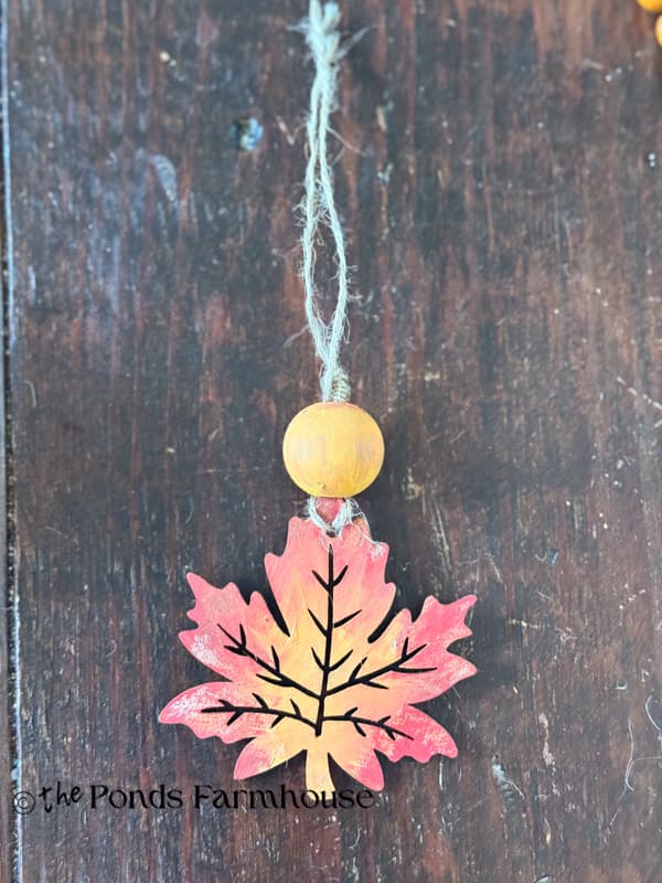 adding painted wooden leaves & beads to jute twine