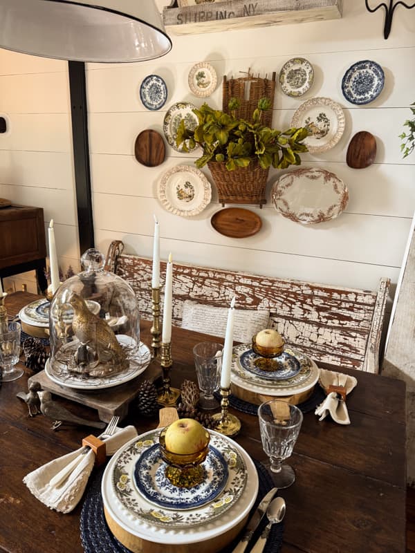 Fall table with blue, brown dishes with plate gallery wall