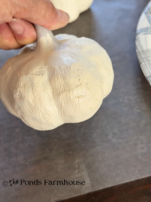 Mixing paint with baking soda to give pumkins a textured pottery appearance