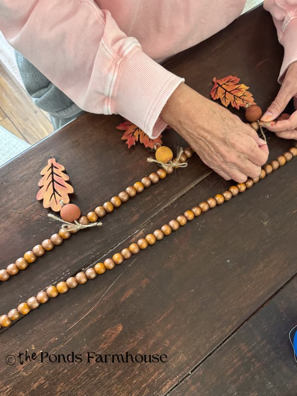 tie the wooden leaves onto the bead garland