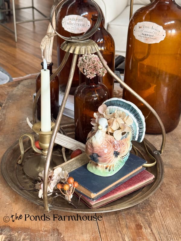 Vintage Turkist Brass Tea Tray decorated with thrifted books, turkey planters, brass candleholder & amber bottle