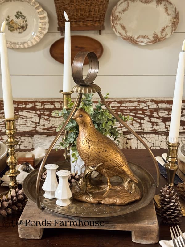 brass tray with pheasant, small plant, salt & pepper Shakers on dining table centerpiece