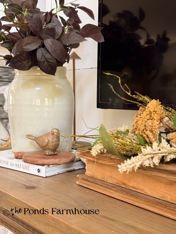 dried stems & Vintage crock with gold bird on cozy fall mantel