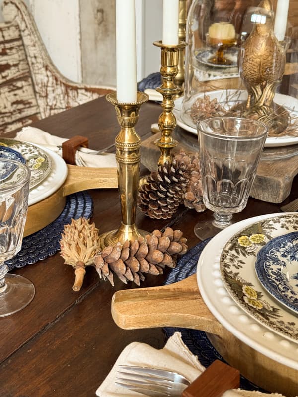 pinecones and dried magnolia seed pods scattered on fall table centerpiece