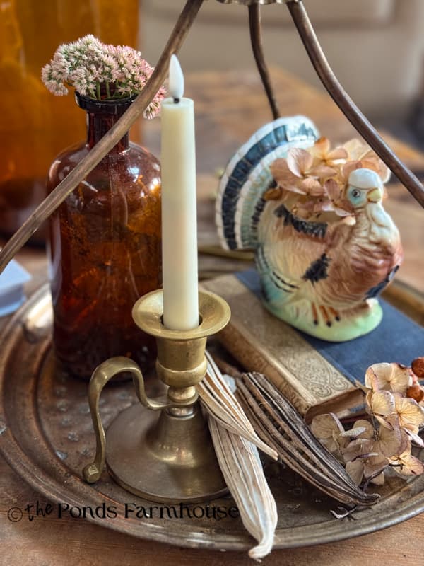 Vintage turkey, brass candle holder and amber bottle on vintage brass tea tray