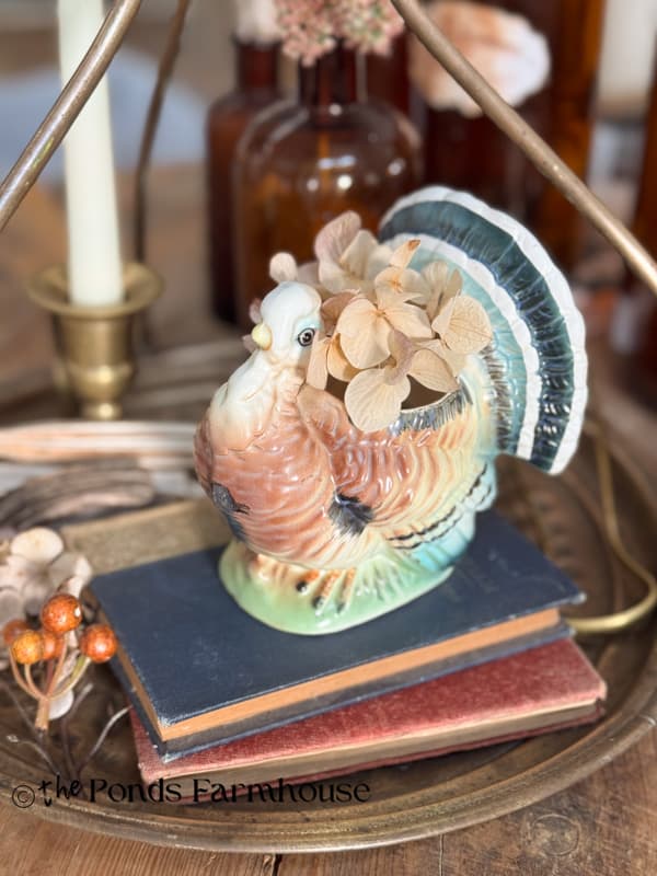 vintage turkey planter with dried hydrangea blooms on vintage books