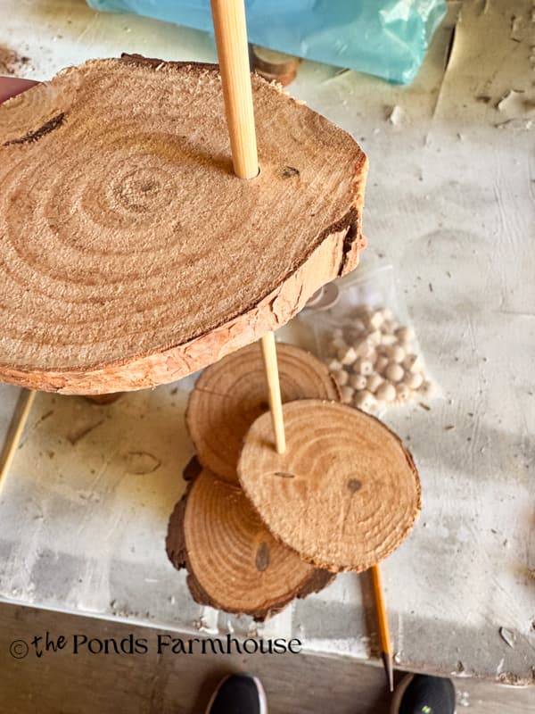 Add wood slices to dowel rod for Christmas Tree assembly