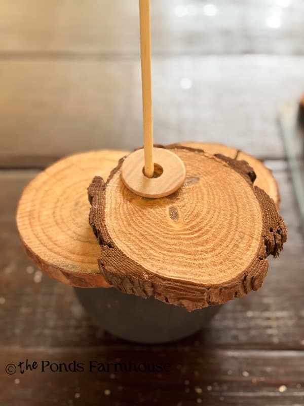 Add wood slices to dowel rod with spacers