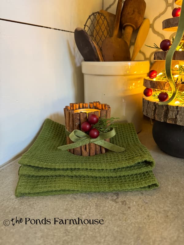 cinnamon stick tea light candle holder with upcycled tin cans on kitchen countertop