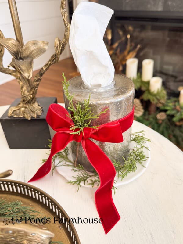 DiY Mercury glass Lampshade tissue holder decorated with red bow and cedar for Christmas side table.