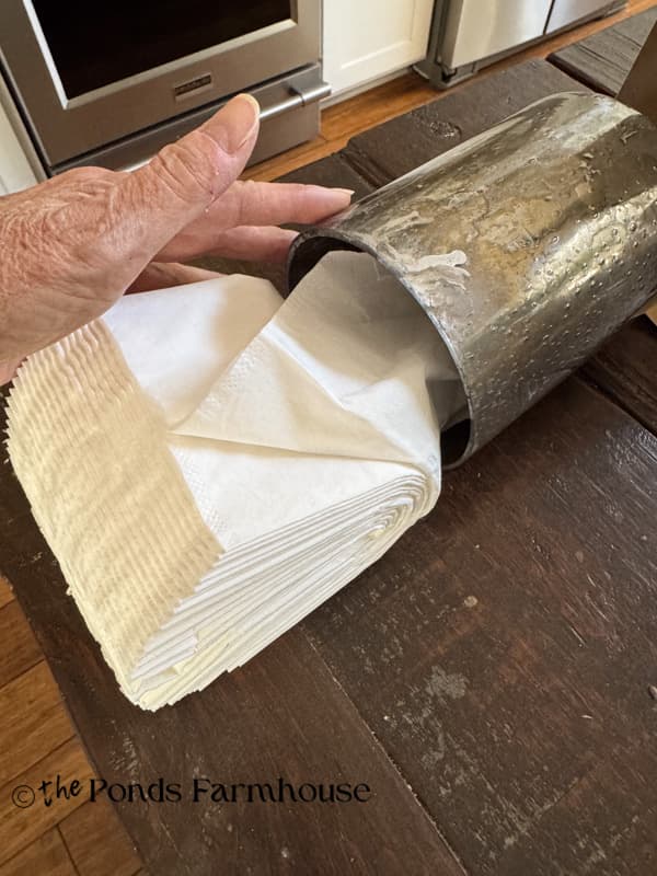 placing the stack of tissues into the glass lampshade