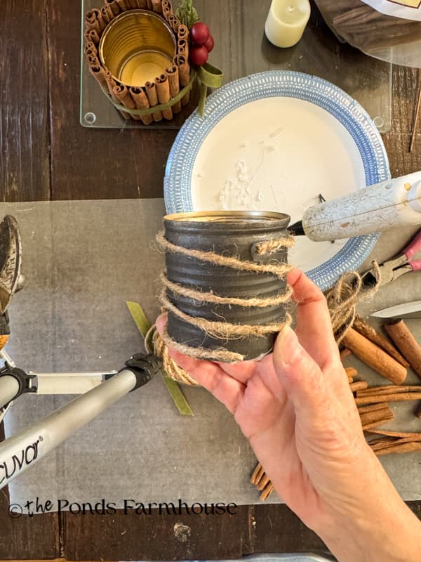 wrap jute twine around the tin can securing with hot glue